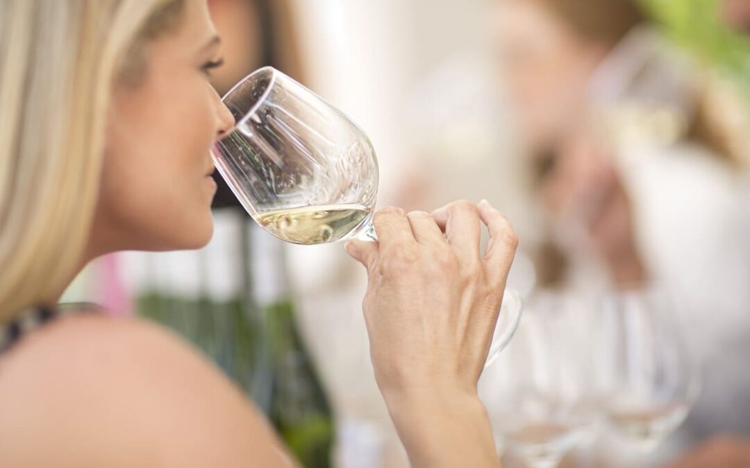 woman smelling white wine during wine tasting