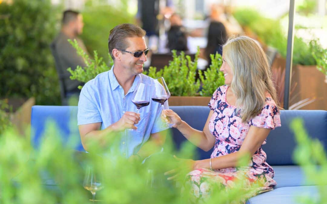 A couple toasts their wine glasses during their Napa Valley Trip to Cornerstone Cellars