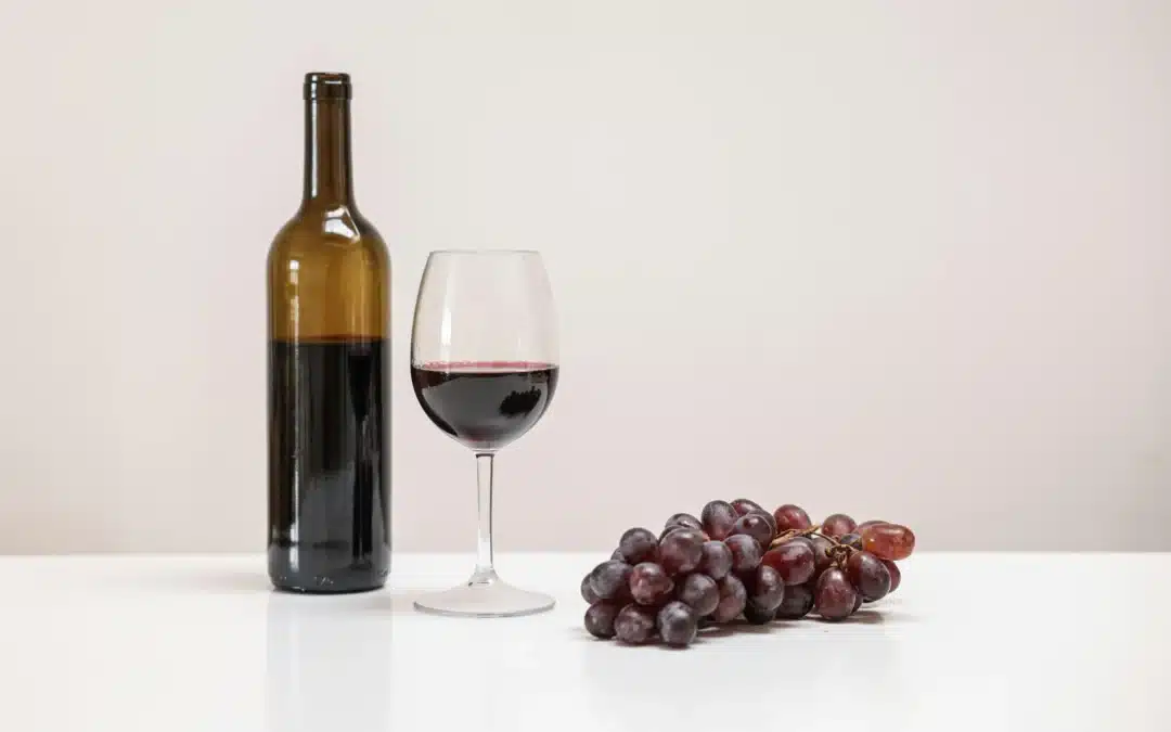 image of a wine bottle, glass and grapes